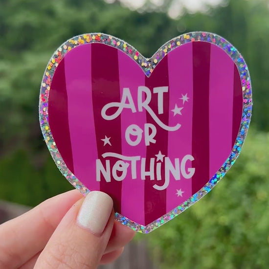 Cute "Art or Nothing" sticker with a pink striped background and a glitter edge